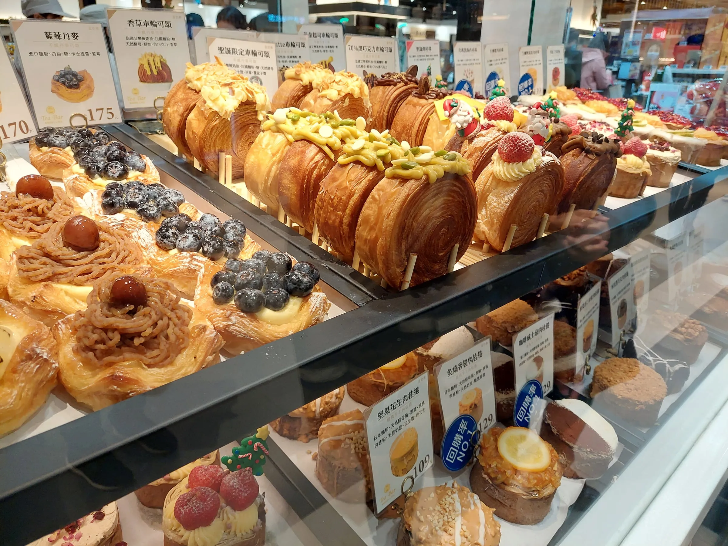 A bakery counter lined with croissants and pastries