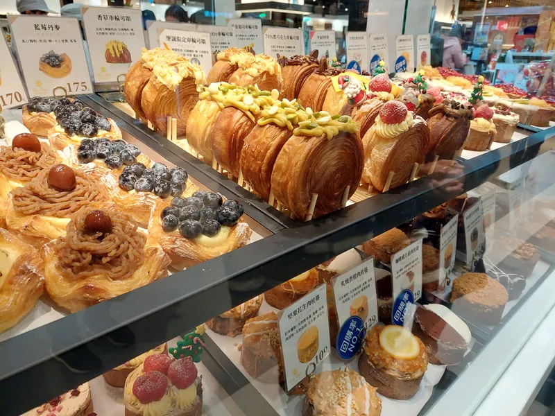A bakery counter lined with croissants and pastries