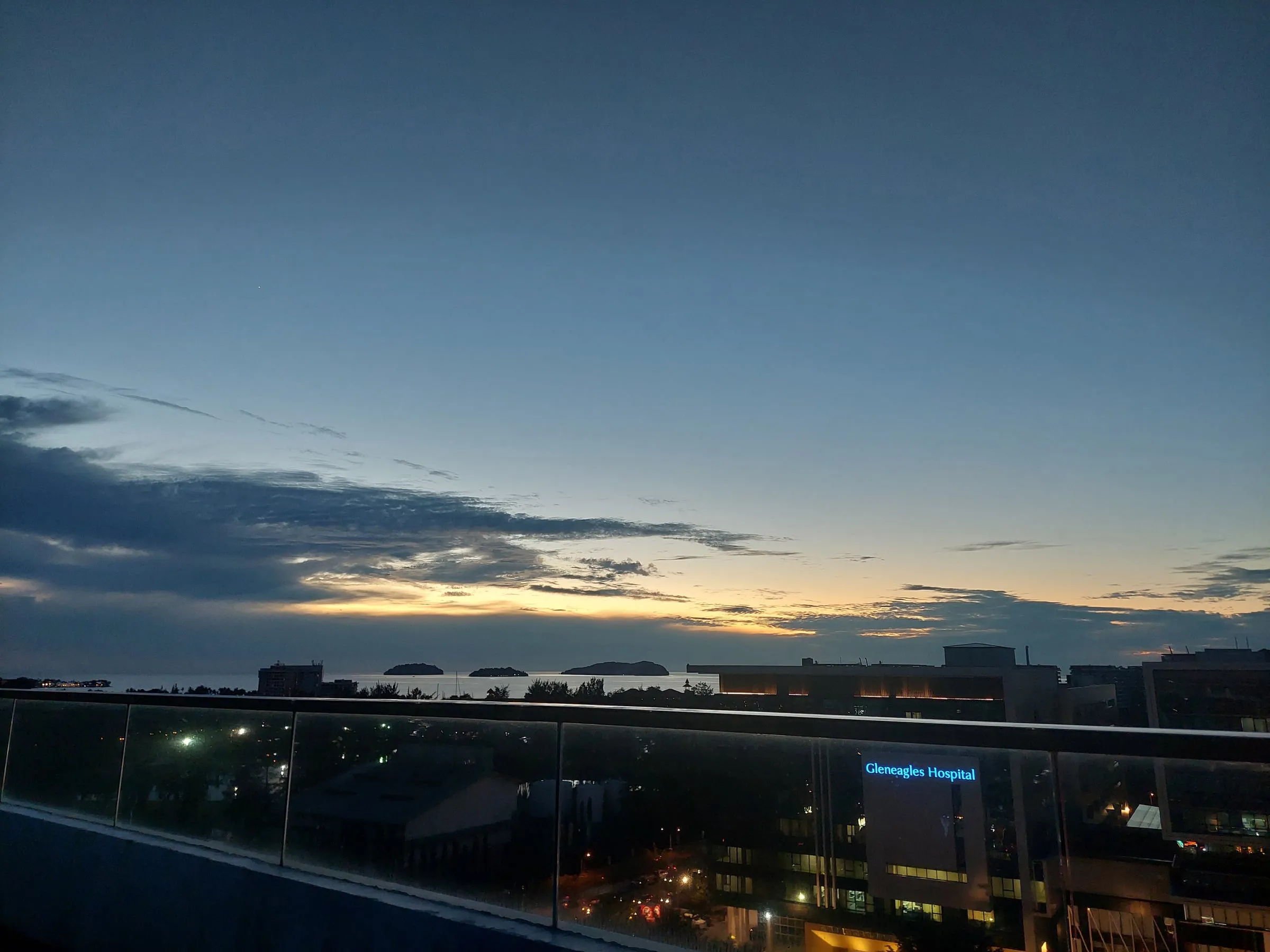 View from a high balcony as the sky darkens, with the last light of sunset under distant clouds
