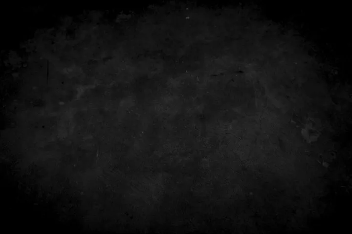 Close-up of a dark, grainy concrete or stone surface with a soft vignette